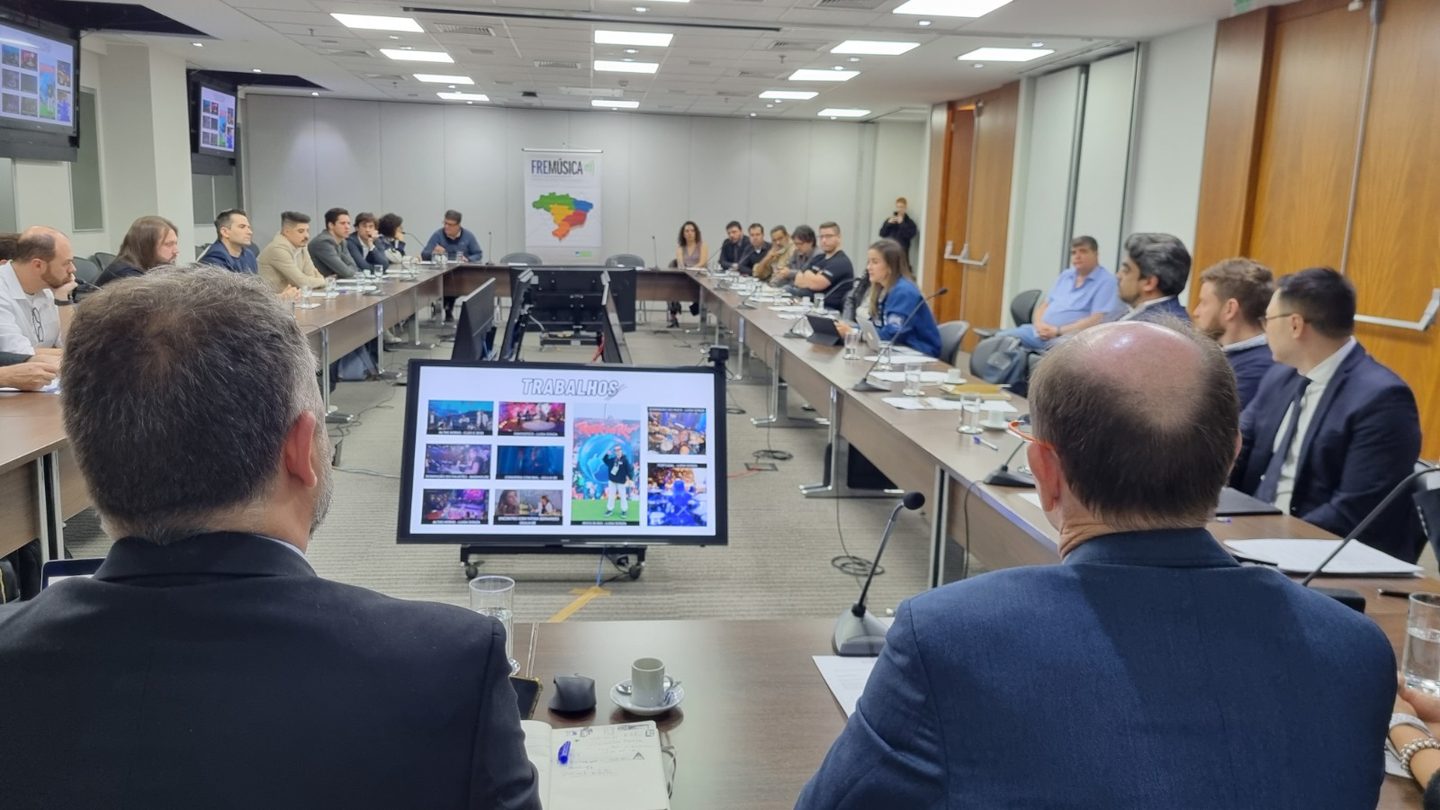 Associados da ANAFIMA reunidos em torno da mesa institucional, acompanhando a apresentação dos trabalhos do setor.